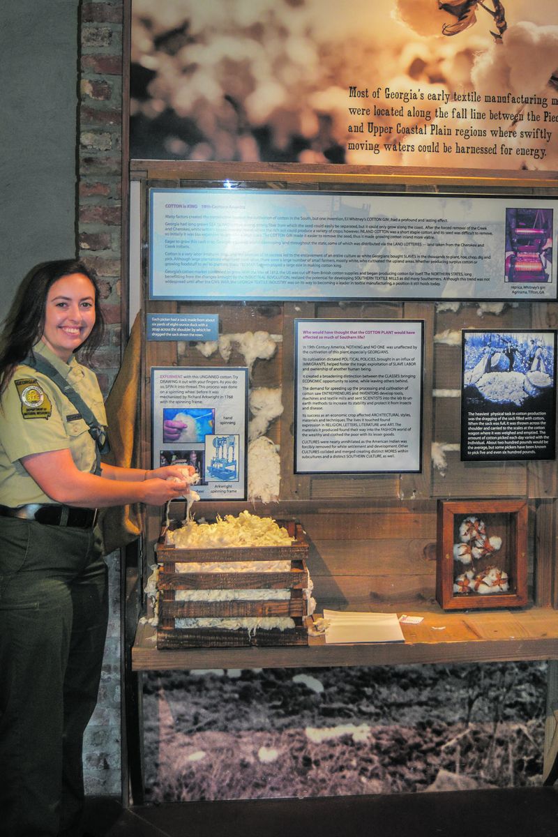 Sarah Kelehear holds cotton next to an exhibit inside the visitors center.