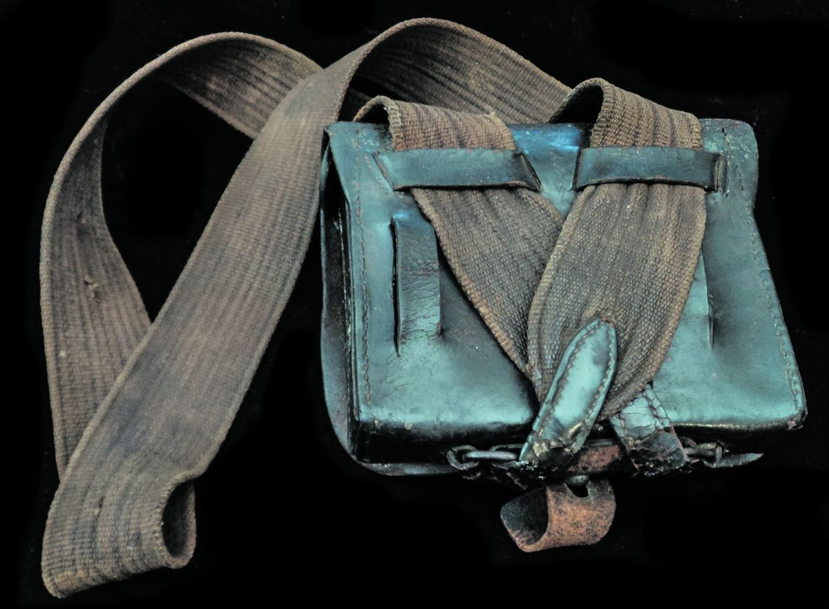 Though manufactured with only over the shoulder sling loops, the soldier cut slots in the back so that he could lock the box into position with his waist belt.