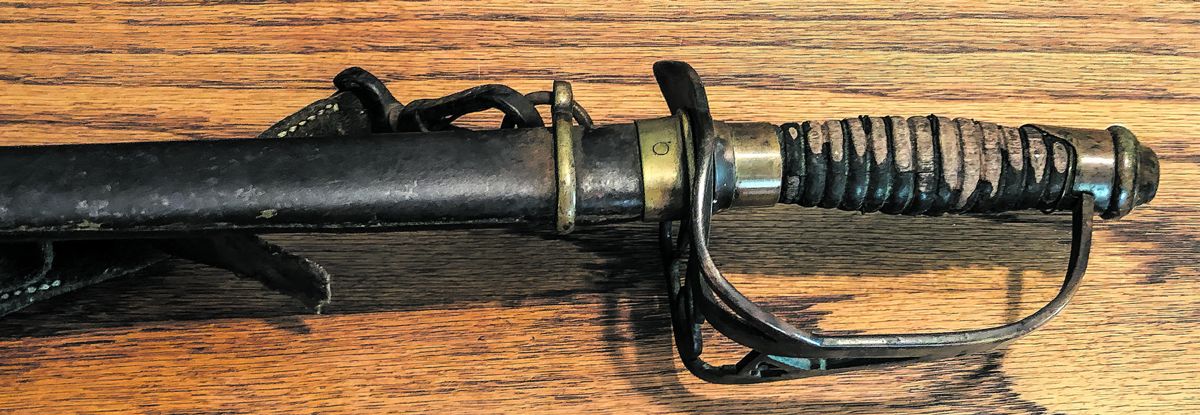 Scabbard has pinned brass throat and narrow brass ring mount standard to this pattern.