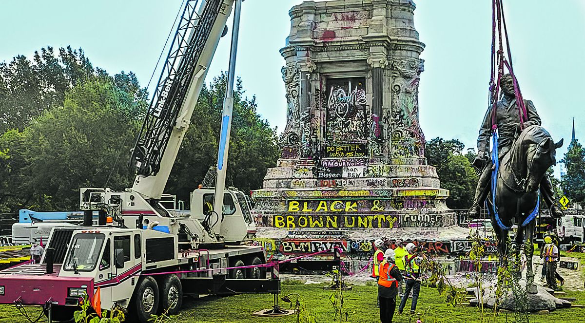 Lee’s statue being lowered from its pedestal right before being cut into smaller pieces.