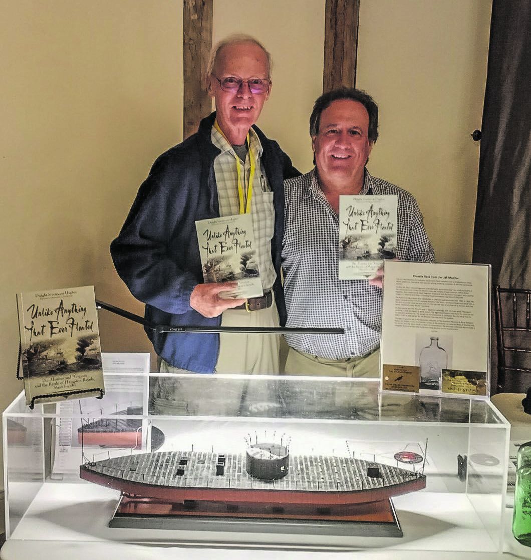 Dwight Hughes and Ted Savas pose with Dwight’s book, which Ted published, Unlike Anything that Ever Floated.