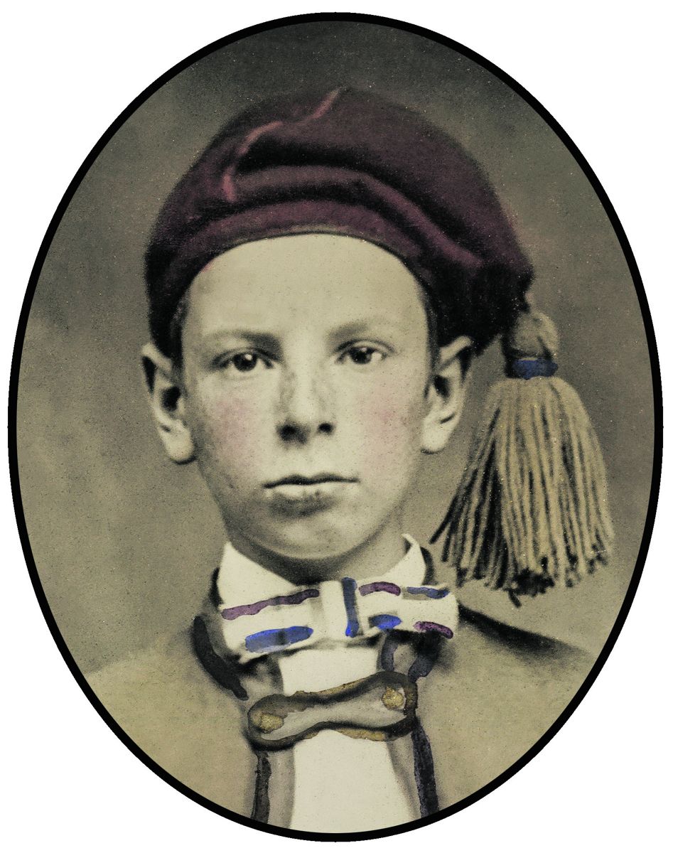 His cap appears to be a combination of a stocking cap and a fez. The large tassel is golden in color with a blue band. The bow tie may be a prop clipped onto the collar. The closure band replaces buttons on the jacket that is meant to be open, On an adult, there might have been a decorated vest over the shirt, but it is not on this youngster.