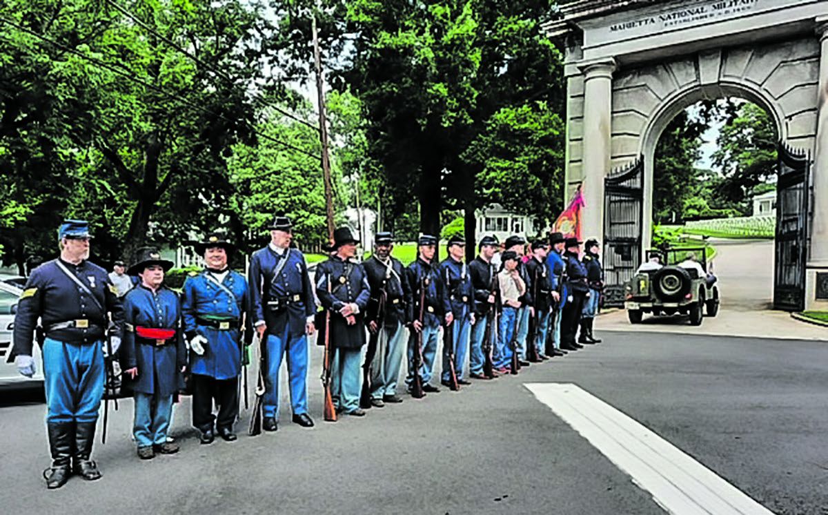 At the gate of the Marietta National Cemetery, the following men are in the honor guard. Jim Bryja, Mike Reither, Fred Purmort, James Hayes, Bill Miller, Rik Kirk, Philip Solida, Gary Burke, Marj Dungan, and William Reither.