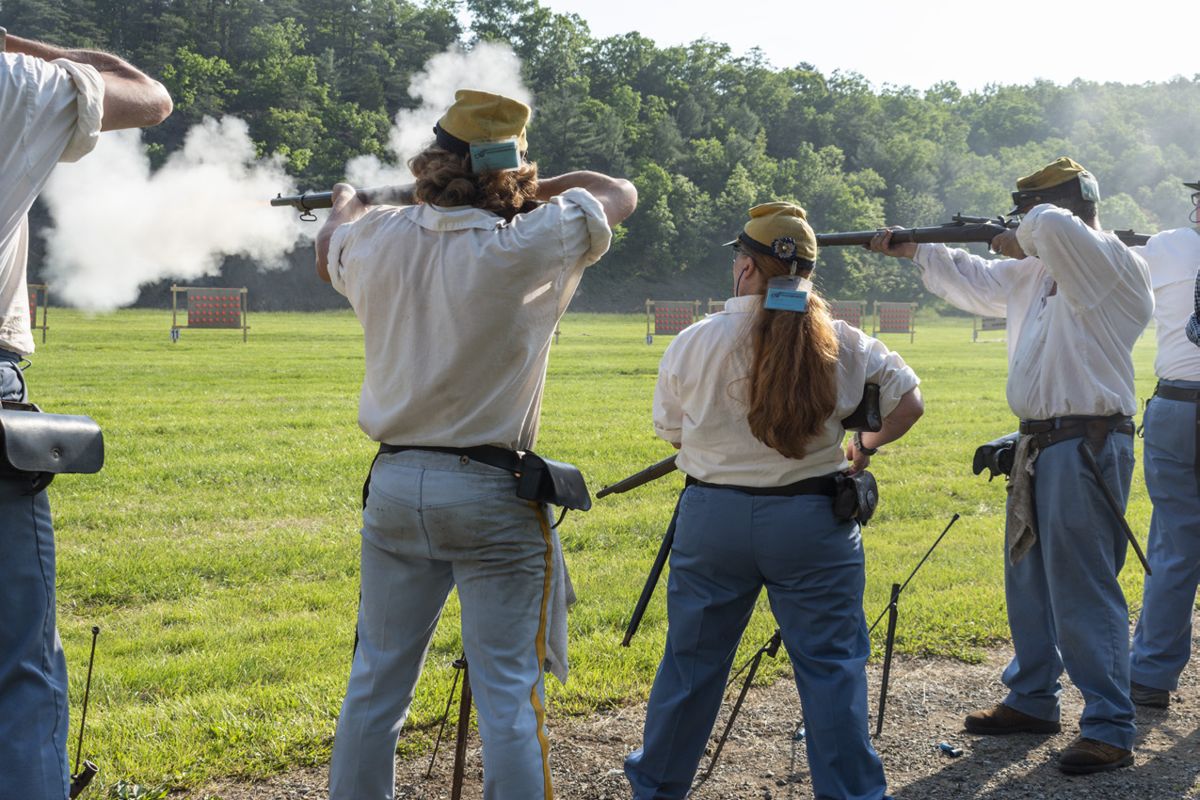 Many generations of skirmishers have grown up in this sport. In this photo, Katie and Tim Scanlan stand with their son Colin to shoot clay pigeons on a cardboard backer at the start of the musket competition. (Ericka