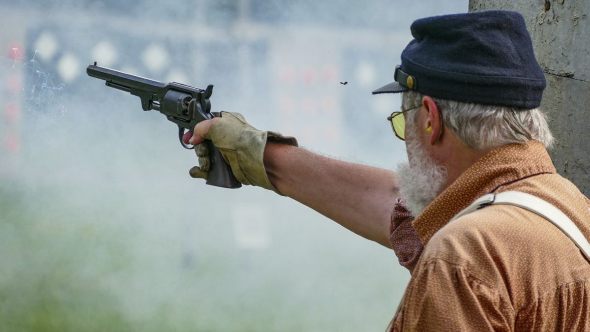 Many generations of skirmishers have grown up in this sport. In this photo, Katie and Tim Scanlan stand with their son Colin to shoot clay pigeons on a cardboard backer at the start of the musket competition. (Ericka