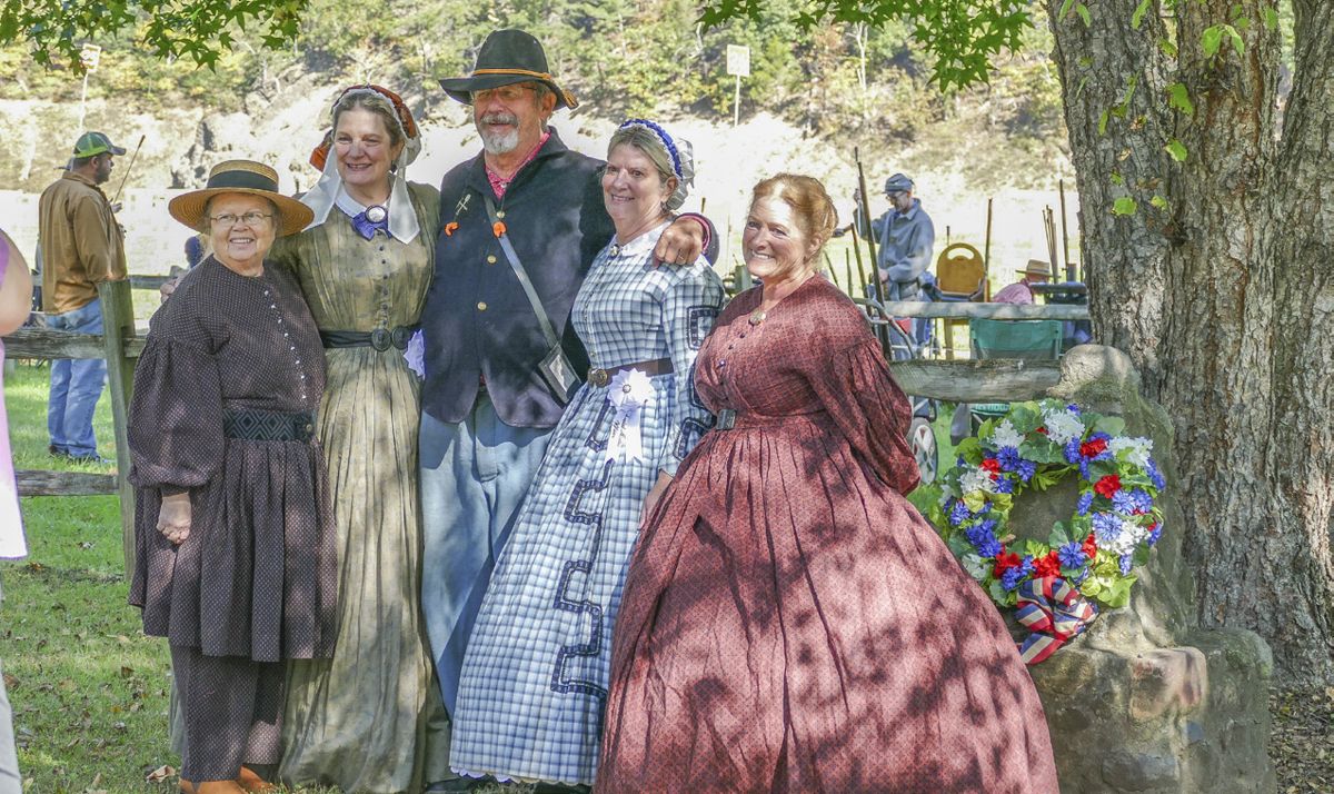 The seamstresses of the N-SSA Costume Committee exhibit their talent in a variety of Civil War era attire. Here, (L to R) Peggy Edwards-Shaw, Maryanne Greketis, Mary Deneau, and Sharleen West pose with the N-SSA Deputy National Commander David Cole. (Lis Cole)