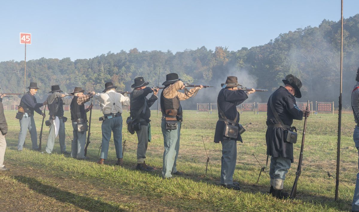 The 29th Wisconsin Volunteer Infantry—who traveled a long way from their home state to Fort Shenandoah in Virginia—loads, aims, and fires during a signature musket match event, 32 clay pigeons on a cardboard backer. (Ericka Curley)