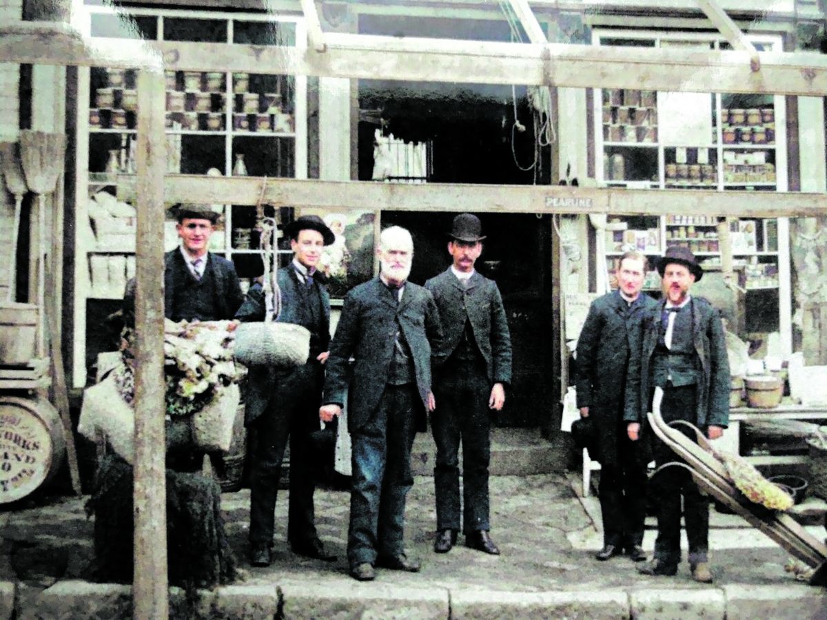 Doggett and Scott store at 205 Commerce St. (Now William St.), circa 1880. Doggett is standing center with the white beard, and Scott is on the right. Colorized by myheritage.com.