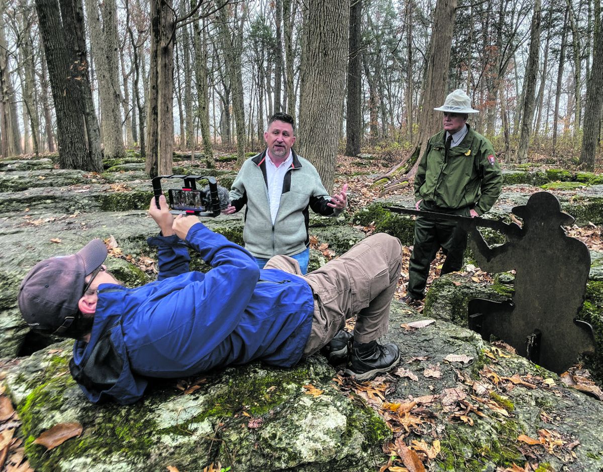 Kris White goes the extra length to get the perfect shot as Chris Mackowski and Stones River National Battlefield’s Jim Lewis talk about the Slaughter Pen for the American Battlefield Trust. Photo courtesy of Garry Adelman.