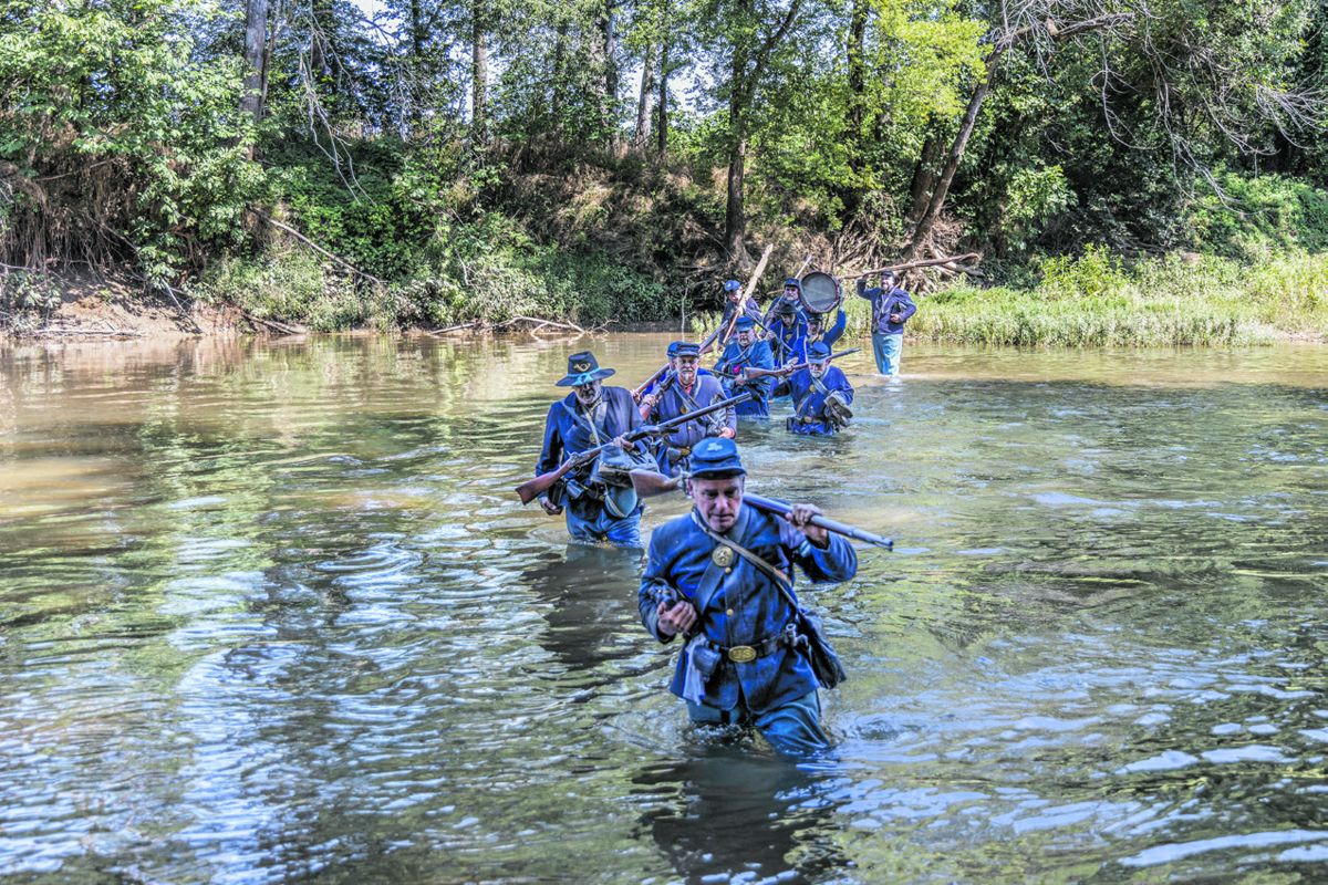 Members of the 14th and 8th Conn. wade across Morton’s Ford on the Rapidan River, led by Sgt. Donald Hamel.