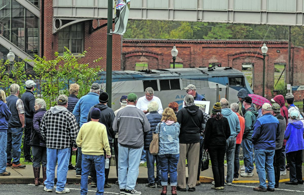 An Amtrak train arrives as Ben Trittipoe (in white shirt) and Don Hakenson tell the group about Jackson’s raid in Martinsburg. (Bill Kamenjar)