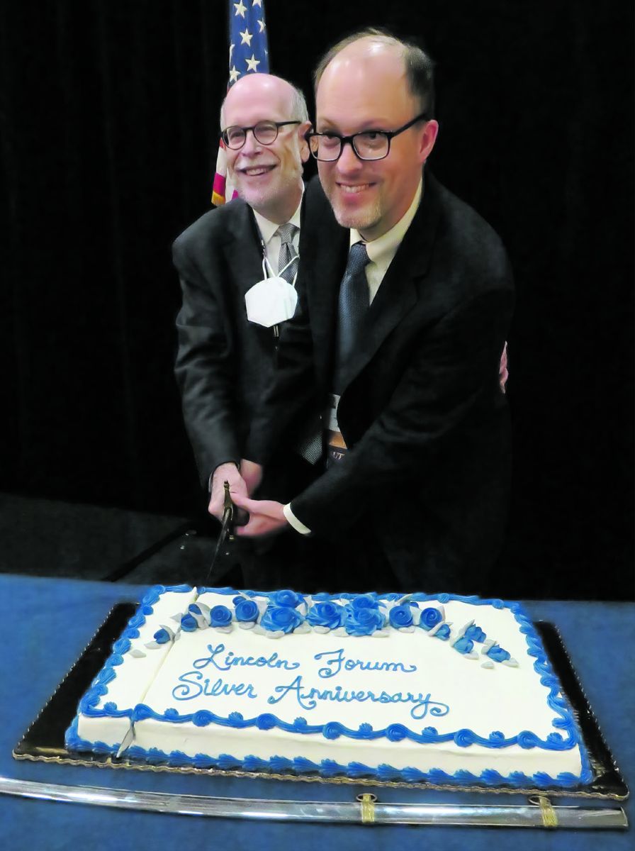 Harold Holzer and Jonathan White cut 25th anniversary cake.