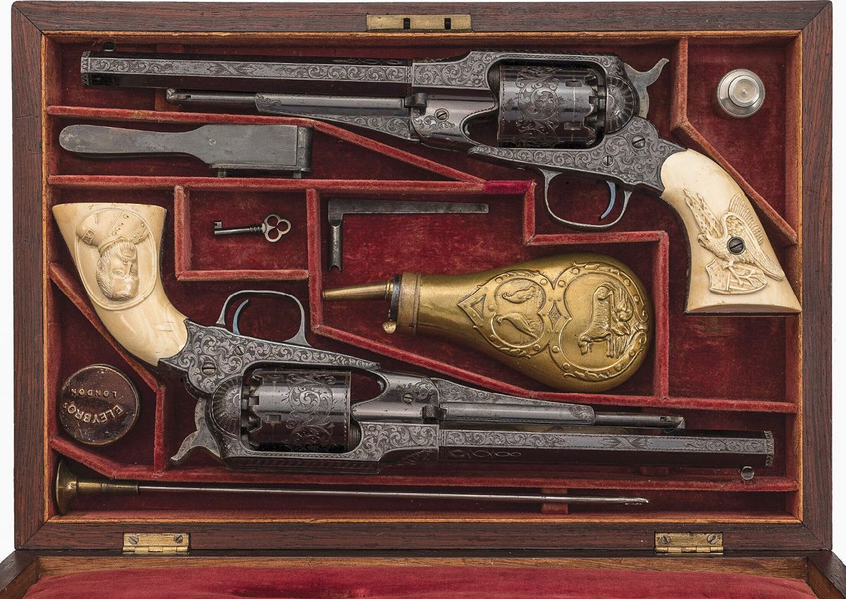 The deluxe rosewood presentation case has a blank lid escutcheon, pheasant and dog pattern powder flask with sloped charger, oiler, blued ball/bullet mold, L-shaped combination tool, cleaning rod, key, and Eley Bros. cap tin.