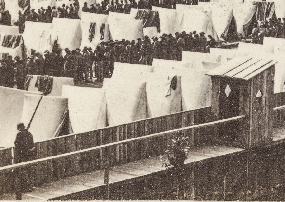 Enlargement showing a guard holding a rifle and the guard shack on the right.