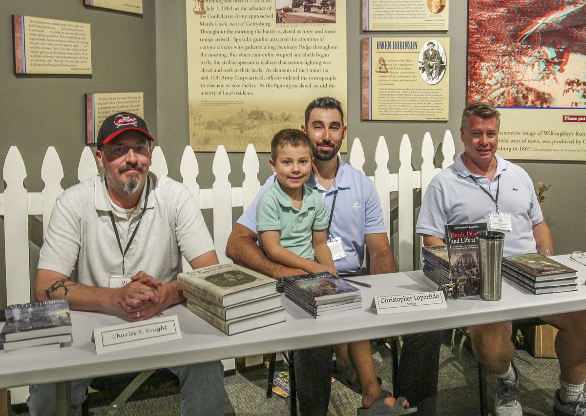 Charlie Knight, Chris Loperfido and son Vinny, and Harold Knudsen, ready to autograph their books.