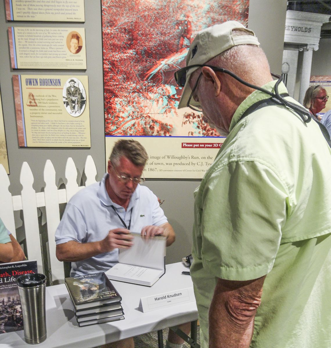 Harold Knudsen signs a book for a customer.