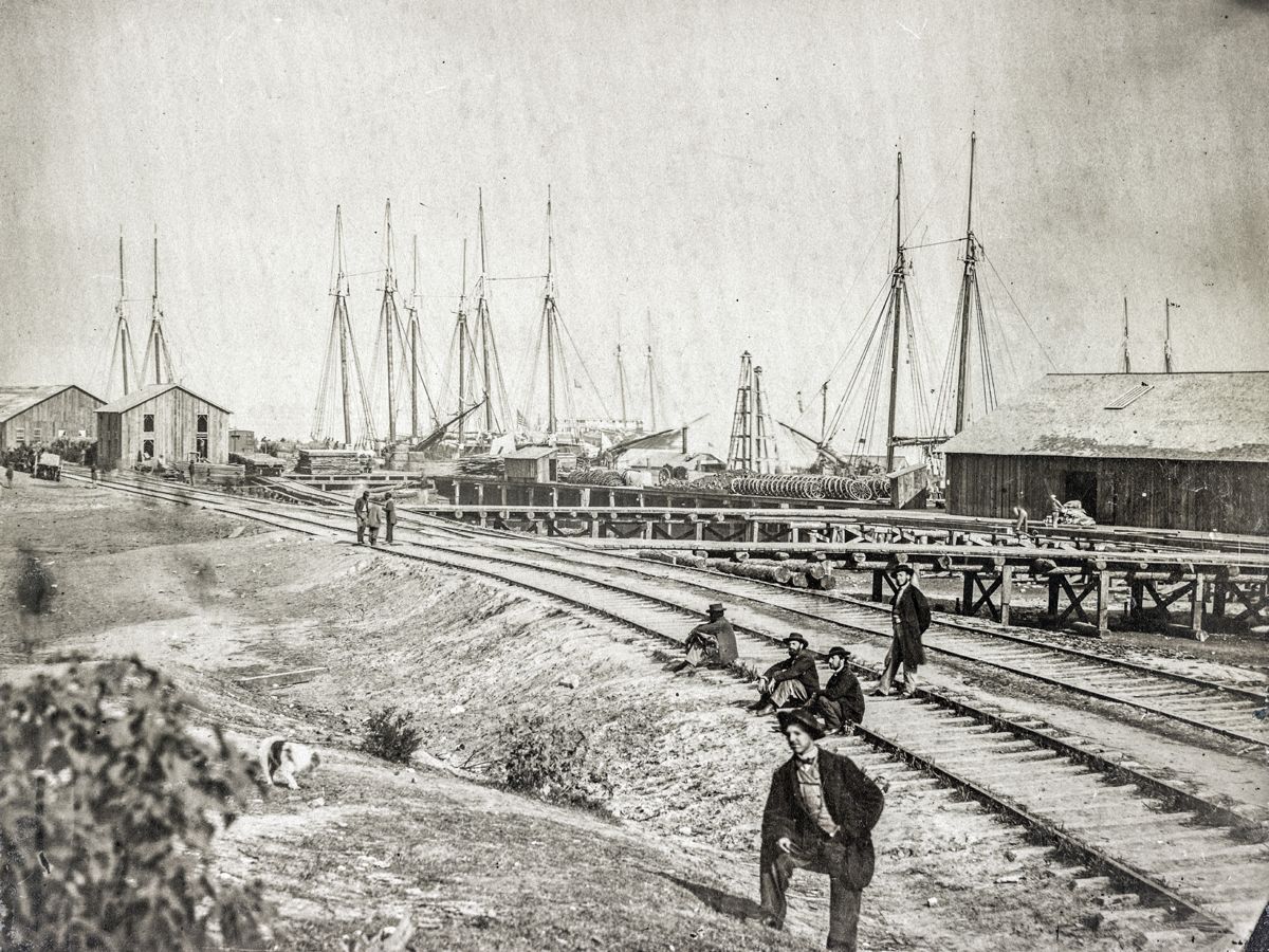 Aquia Creek Landing. Photograph shows a supply landing for the U.S. Army Quartermaster with railroad tracks leading up to the landing and sailing ships in the distance. (Library of Congress)