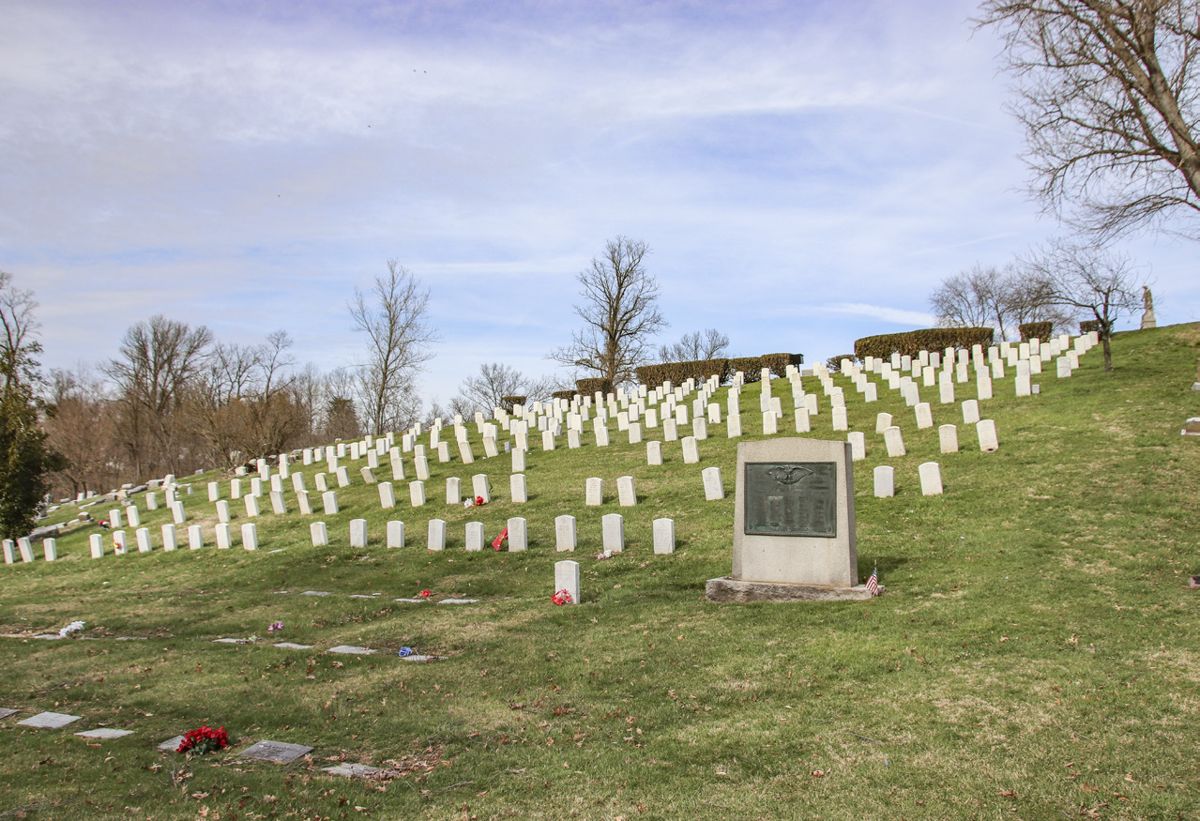 The Fort Thomas post cemetery with the Newport, Ky., World War II memorial monument in the foreground. Medal of honor winner Drum Major Thomas M. Doherty’s grave site is located in front of the central gap in the hedgerow.
