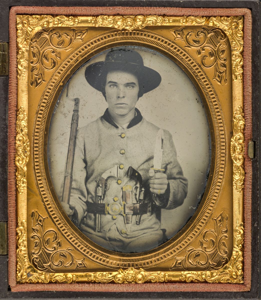Confederate soldier in uniform wearing a Texas or Mississippi star two-piece belt buckle with two revolvers, side knife, and bayoneted rifle. (Liljenquist Family Collection of Civil War Photographs, Library of Congress)
