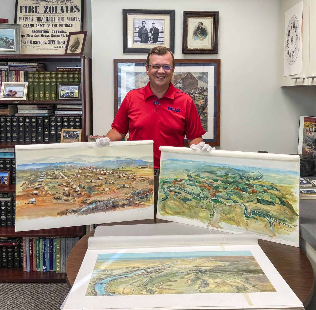 MCWI’s director Jonathan Noyalas with two of artist Paul Salmon’s original watercolors.