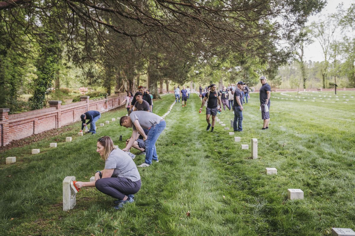 Park Day (2023) participants help maintain gravestones at Poplar Grove National Cemetery. Photo by Jamie Betts.
